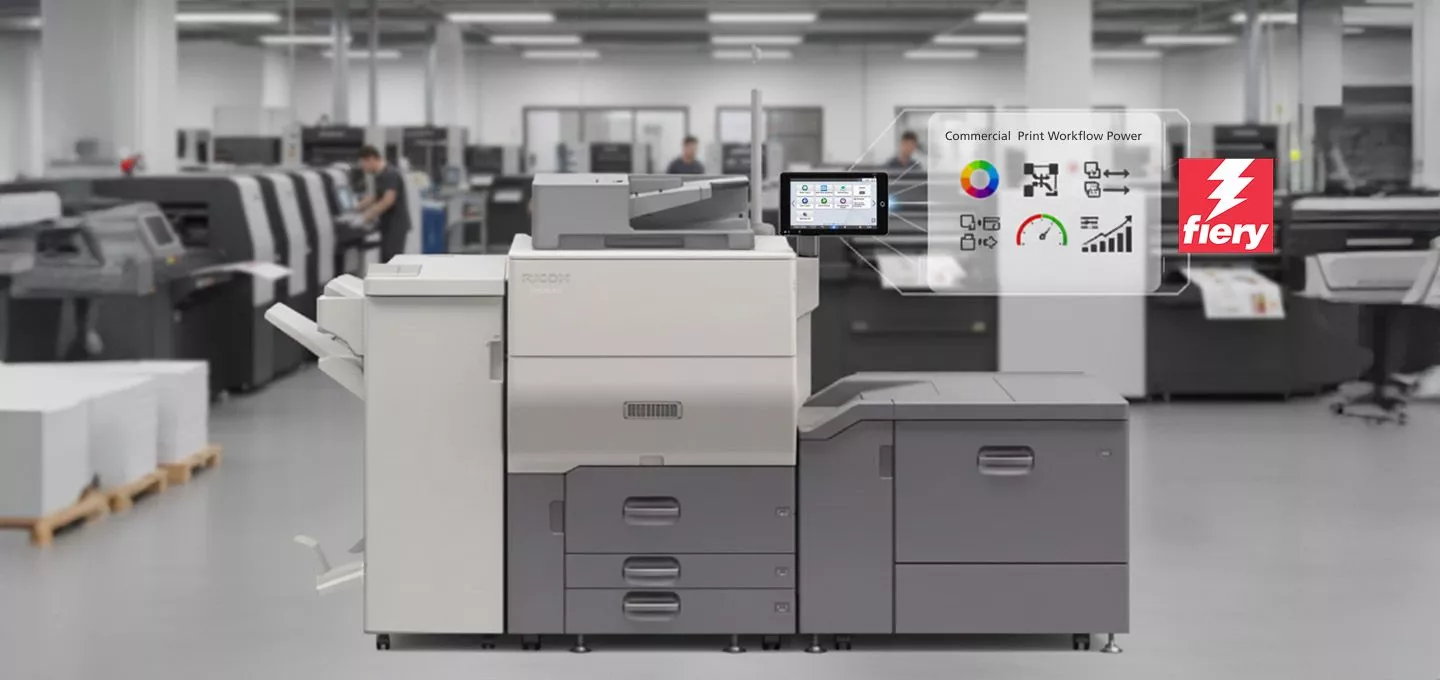  A Ricoh commercial printer is in a large print shop or warehouse, with other industrial printers visible in the background. A transparent graphic overlay floats in the air to the right of the printer, displaying the text "Commercial Print Workflow Power" and icons related to color management, workflow, and performance metrics. The logo for Fiery is prominently displayed at the bottom right of the graphic.